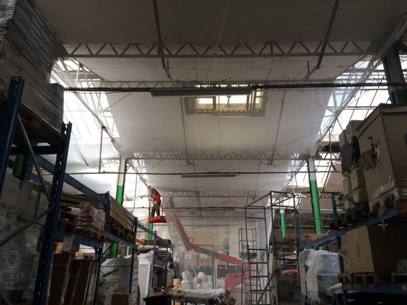 Dans la réserve du magasin Weldom à Saint-Barnabé, Marseille, SPE a effectué la pose des filets pare-gravas.